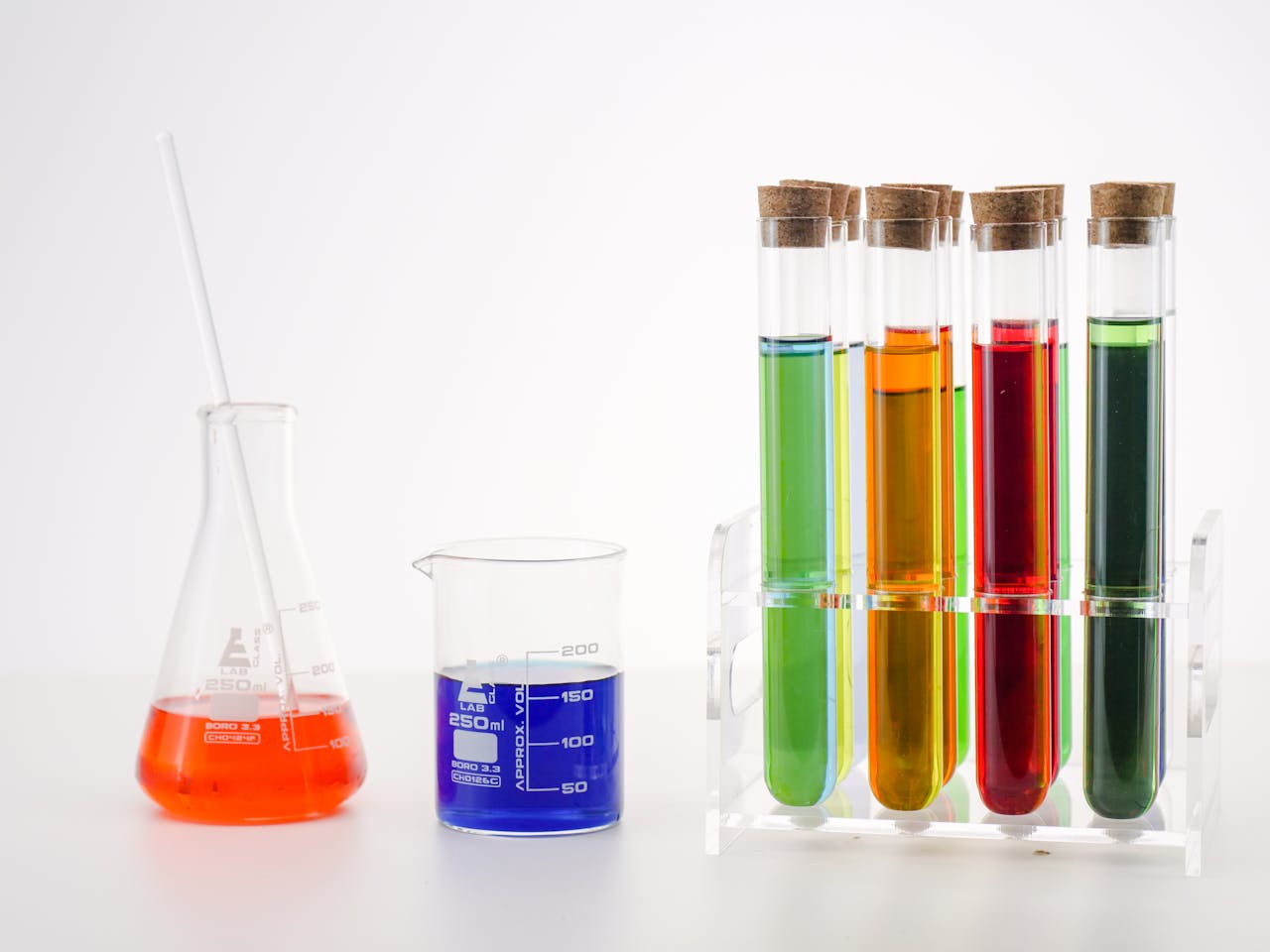 A vibrant arrangement of test tubes, Erlenmeyer flask with colorful solutions in a lab setting.